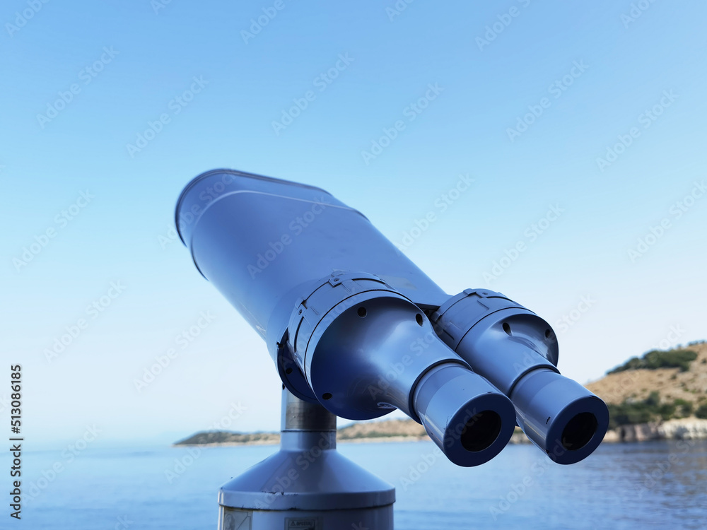 binocular isolated on the blue sky watching on the sea binocular isolated on the blue sky watching on the sea