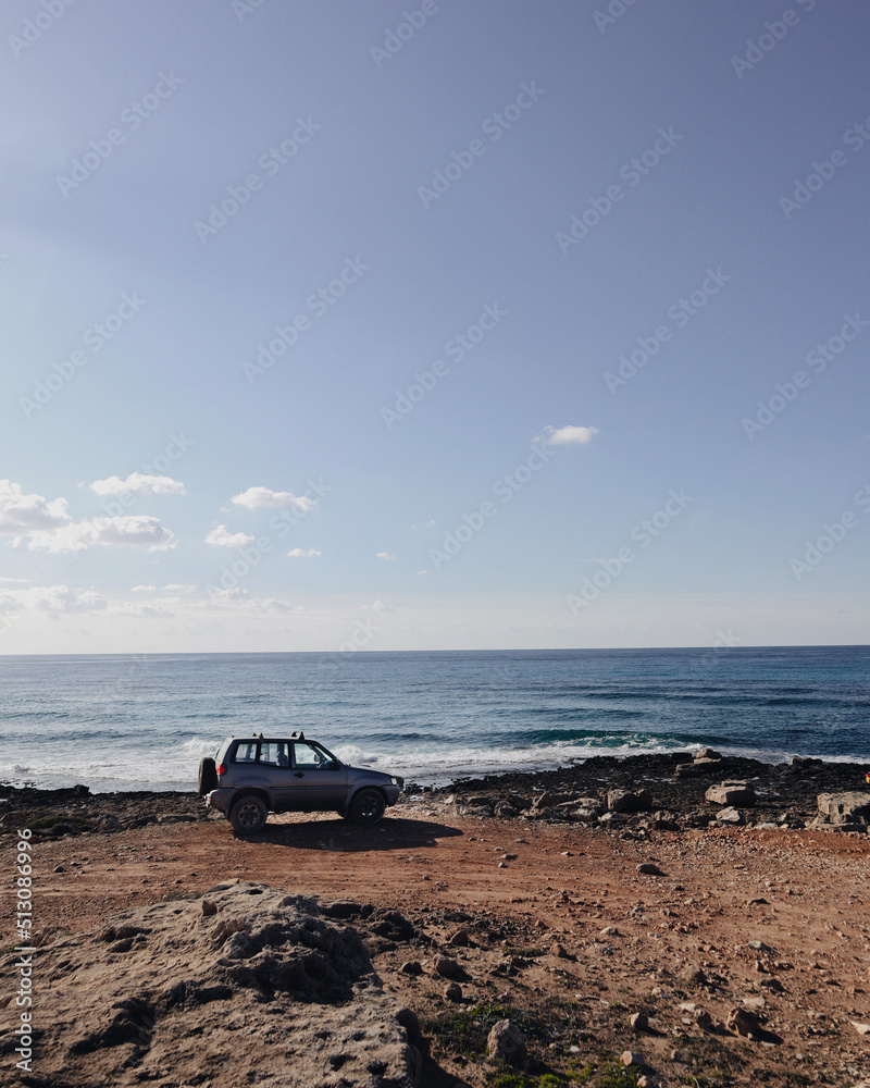 Car is parked at the edge near the sea in sunny day. Car is parked at the edge near the sea in sunny day.