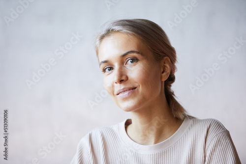 Portrait of smiling attractive young woman with beautiful color of hair wearing cozy sweater