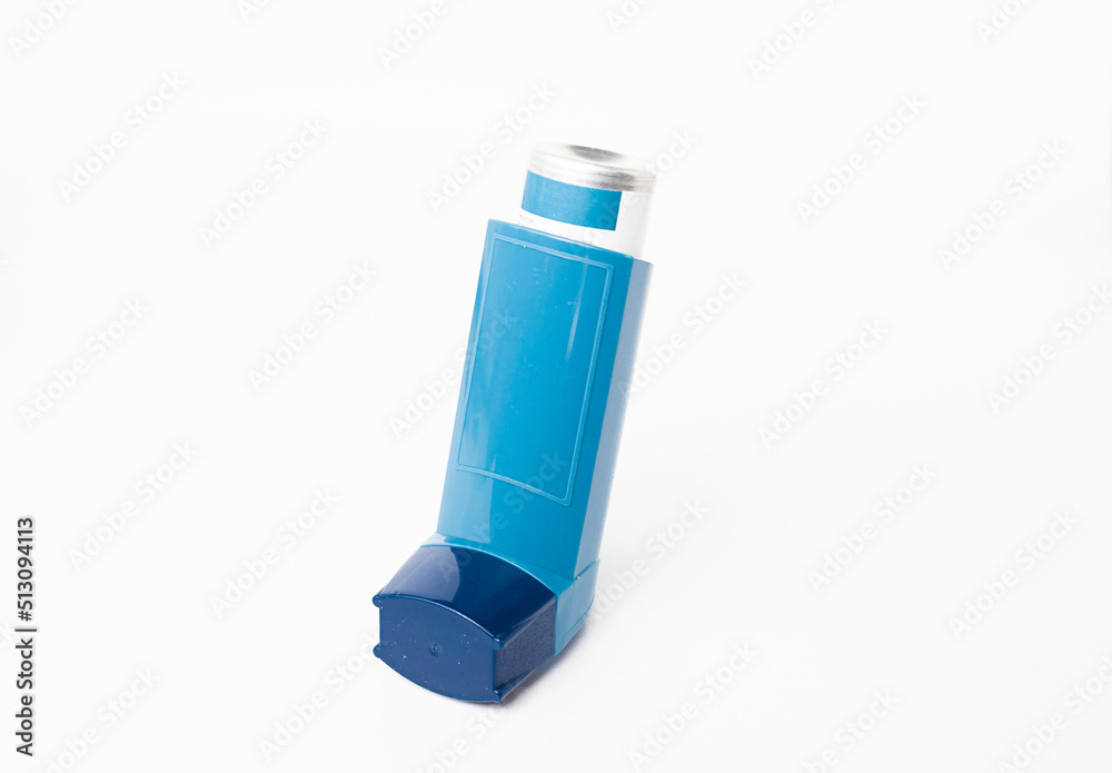 Blue asthma inhaler with blank label isolated on white background. Pharmaceutical product is