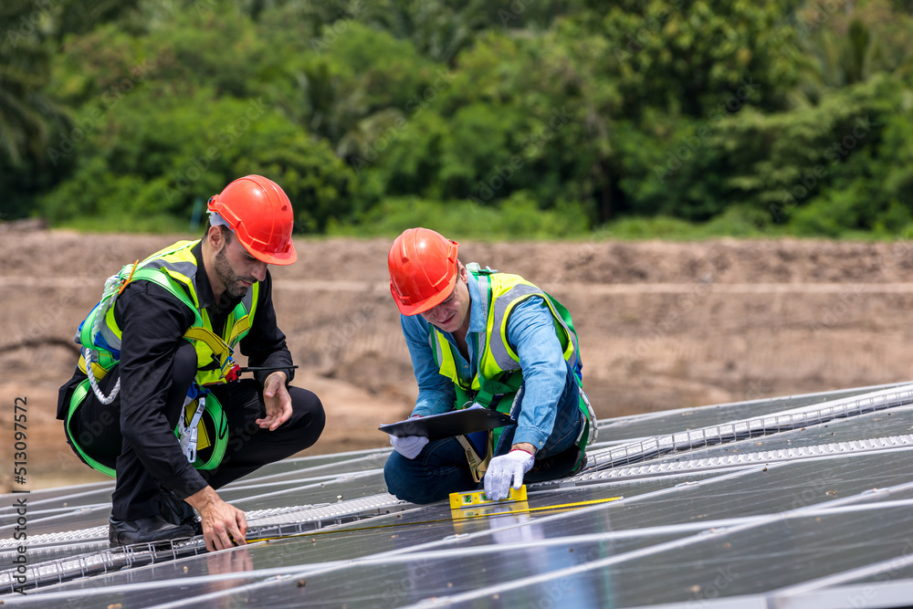 Engineer working setup Solar panel at the roof top. Engineer or worker work on solar panels or solar cells on the roof of business building Engineer working setup Solar panel at the roof top. Engineer or worker work on solar panels or solar cells on the roof of business building