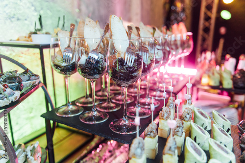 Large table with snacks of different types at a party with creative disco lighting.