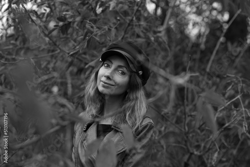 Portrait of beautiful woman in a cap in the forest in black and white