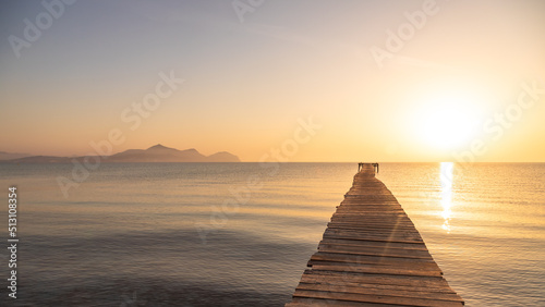 Fototapeta Naklejka Na Ścianę i Meble -  Wooden pier in the beach. Wood bridge in the beach. Sunset in the beach, golden hour. Mallorca island, 