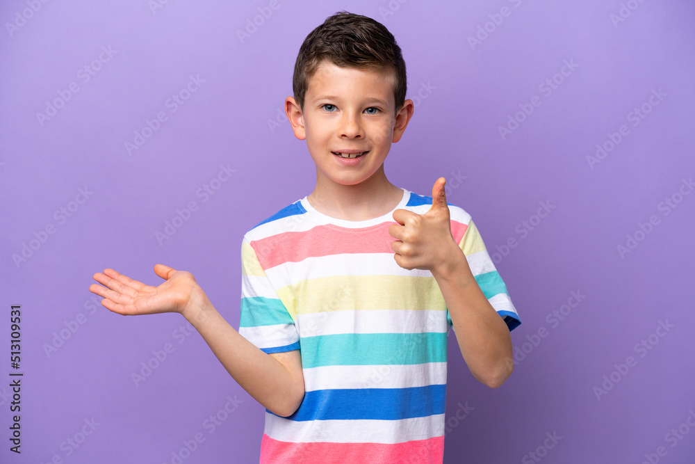 Little boy isolated on purple background holding copyspace imaginary on the palm to insert an ad and with thumbs up Little boy isolated on purple background holding copyspace imaginary on the palm to insert an ad and with thumbs up