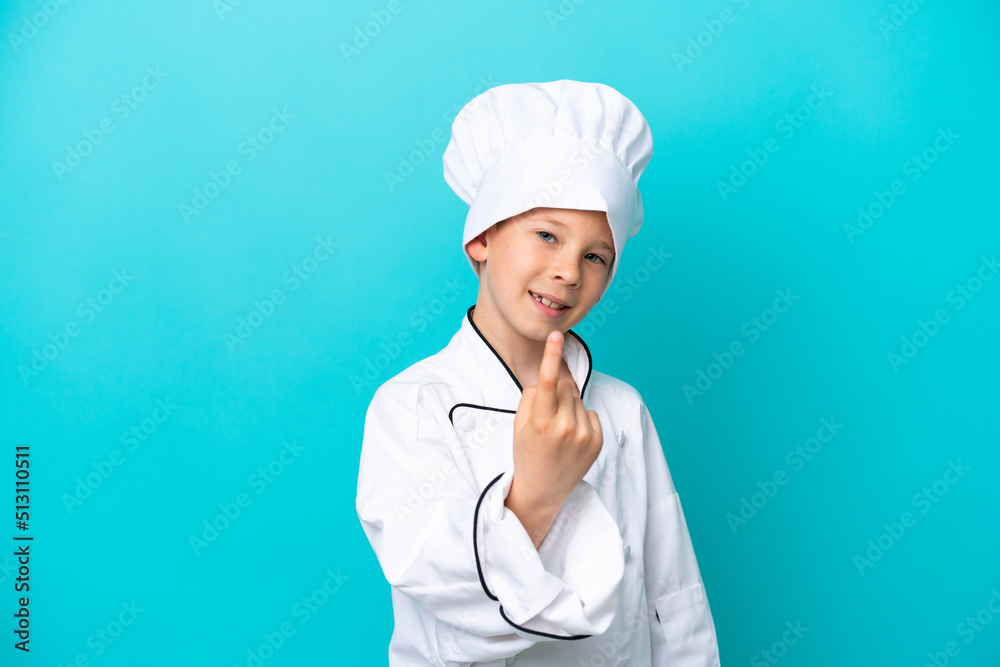 Little chef boy isolated on blue background doing coming gesture Little chef boy isolated on blue background doing coming gesture