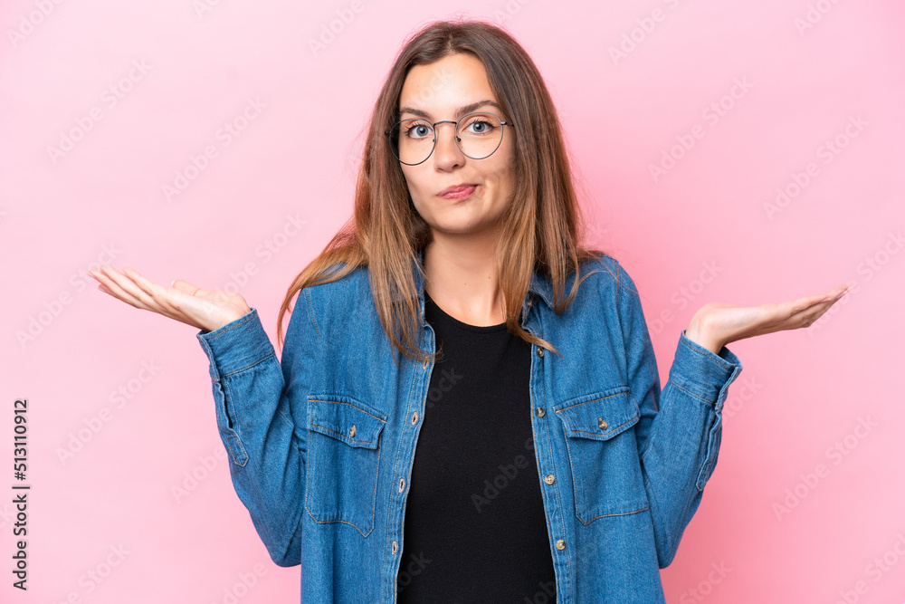 Young caucasian woman isolated on pink background having doubts while raising hands Young caucasian woman isolated on pink background having doubts while raising hands
