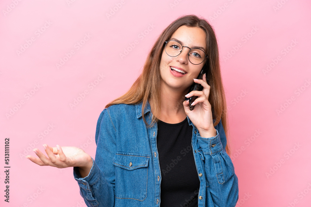 Young caucasian woman isolated on pink background keeping a conversation with the mobile phone with someone Young caucasian woman isolated on pink background keeping a conversation with the mobile phone with someone