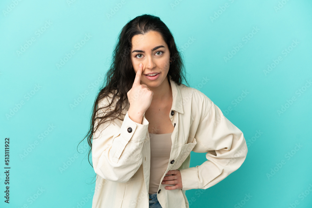 Young caucasian woman isolated on blue background showing something Young caucasian woman isolated on blue background showing something
