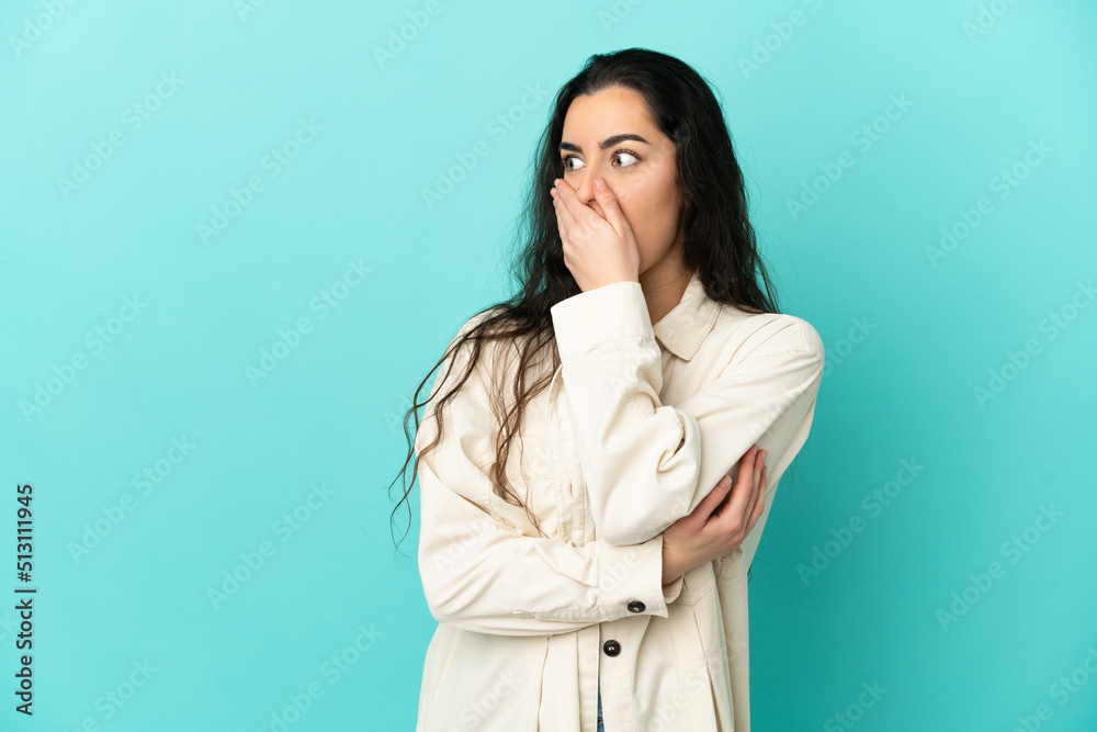 Young caucasian woman isolated on blue background doing surprise gesture while looking to the side Young caucasian woman isolated on blue background doing surprise gesture while looking to the side
