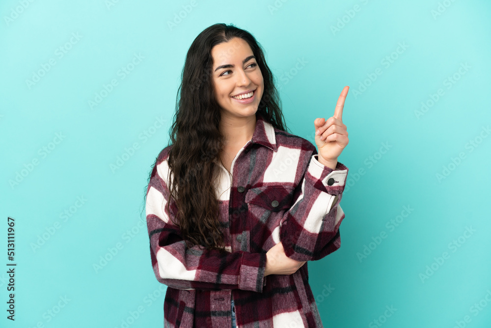 Young caucasian woman isolated on blue background pointing up a great idea Young caucasian woman isolated on blue background pointing up a great idea