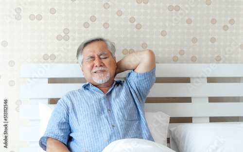Foto Senior Asian man , old man he wake up and sat on the bed , He had pain in the na