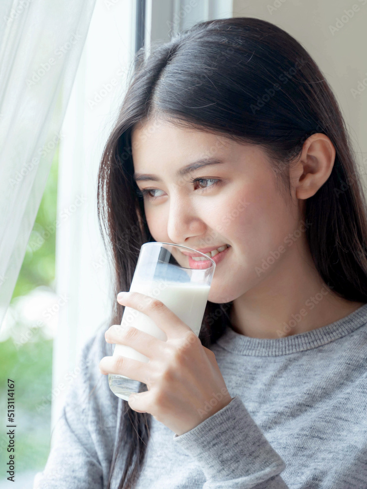 Beautiful beauty Asian woman cute girl feel happy drinking milk for good health in the morning , enjoying time in her home white bedroom background - lifestyle beauty woman concept Beautiful beauty Asian woman cute girl feel happy drinking milk for good health in the morning , enjoying time in her home white bedroom background - lifestyle beauty woman concept