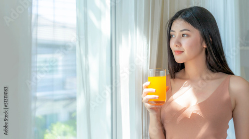 Lifestyle beautiful beauty woman Asian cute girl feel happy enjoy eating diet food , drinking orange juice for good health in the morning