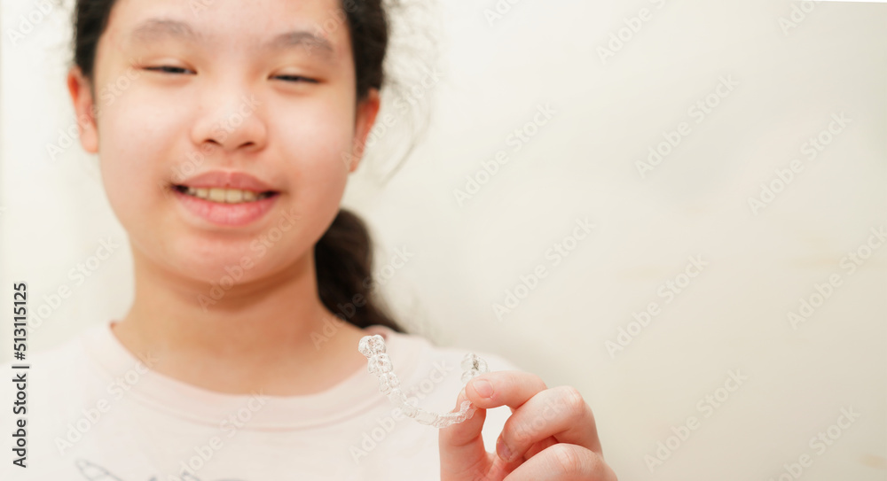 girl hold invisalign brace for tooth correction with smile girl hold invisalign brace for tooth correction with smile