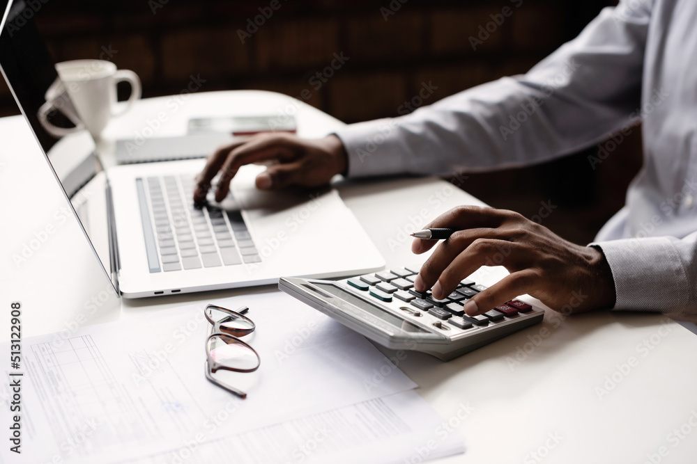 Man accountant using calculator and laptop computer in office, businessman working at home, finance and accounting concept - obrazy, fototapety, plakaty 