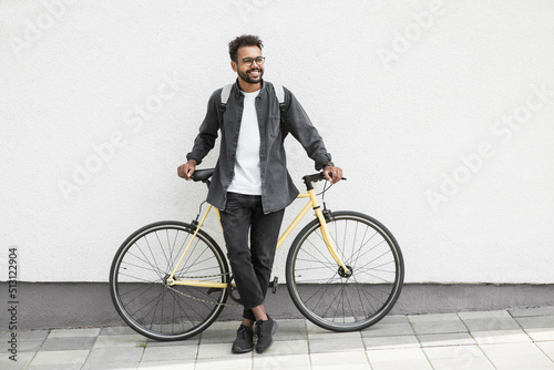 Young handsome man with bike over white wall background in a city, Smiling student man with bicycle smiling outdoor, Modern healthy lifestyle, travel, casual business concept