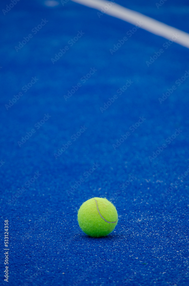 a paddle tennis ball on a blue artificial grass court