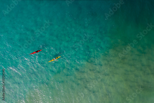  Aerial view of two white kayaks, rowing in the sea with turquoise water