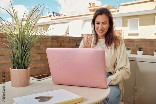 woman on the terrace of her house making a video call with her laptop