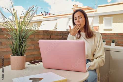 woman on the terrace of her house making a video call with her laptop