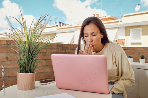 woman on the terrace of her house making a video call with her laptop