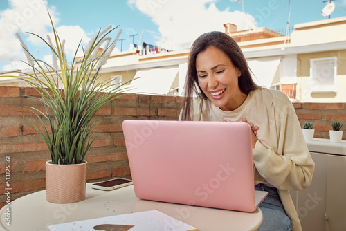 woman on the terrace of her house making a video call with her laptop