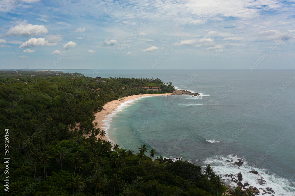 Fototapeta premium Aerial view of sandy beach with palm trees and ocean surf with waves. Sri Lanka.