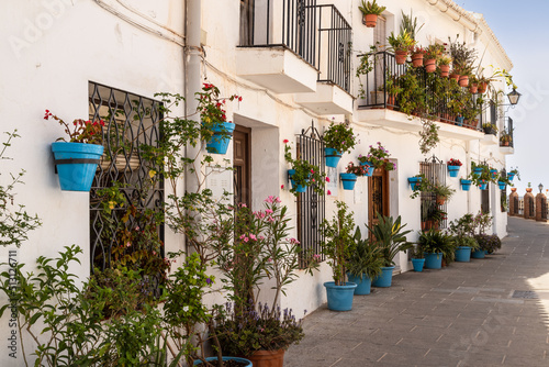 Fototapeta White painted houses with the famous blue flower pots against the wall, in the beautiful mountain village of Mijas in Andalusia; Costa del Sol