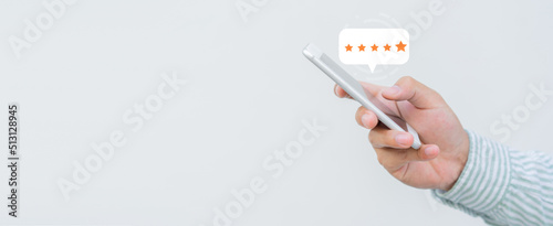 close up on customer man hand pressing on smartphone screen with gold five star rating feedback icon and press level three rank (good) for give score point to review the service business concept