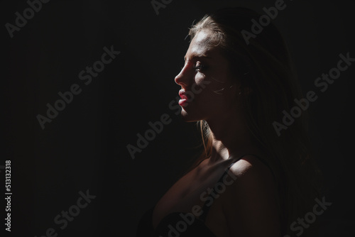 Fototapeta Sexy gorgeous woman with shadows on beautiful face on black studio