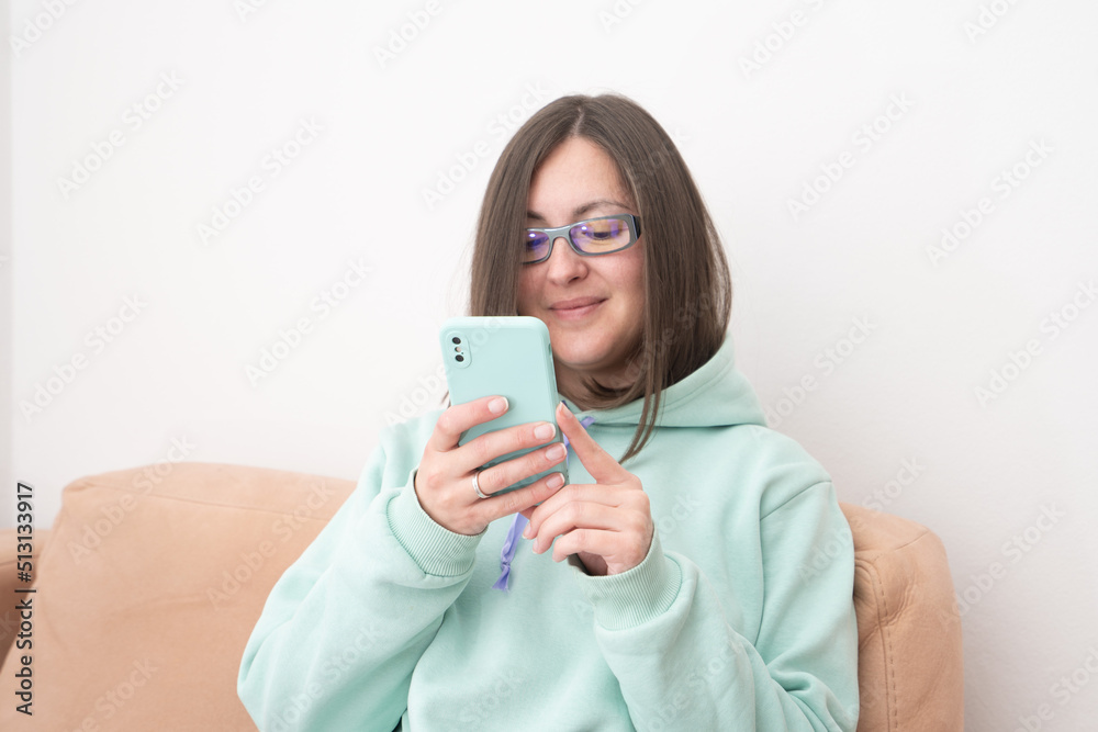 Portrait of a smiling casual woman holding smartphone over white background Portrait of a smiling casual woman holding smartphone over white background