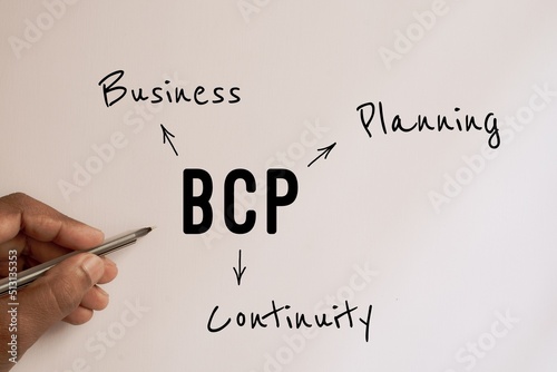 Photography Businessman explaining acronym BCP Business Continuity Plan on white board