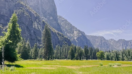 Beautiful nature in Yosemite National Park. Large rock cliffs and a green meadow on a sunny day form an amazing landscape. Summer in the mountains of California sho in the USA. photo