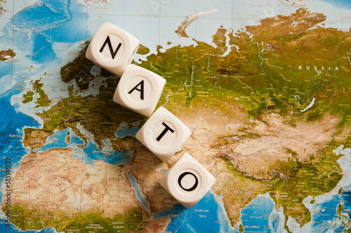 NATO spelled with dice on a world map, concept for the North Atlantic Treaty Organization expanding its members photo