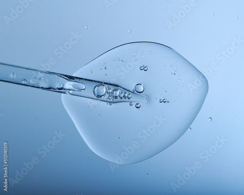 Pipette with bubbles and clear formulation being expelled. Clear liquid with bubbles resembling glycerin, hyaluronic acid or keratin in laboratory or scientific setting.  photo