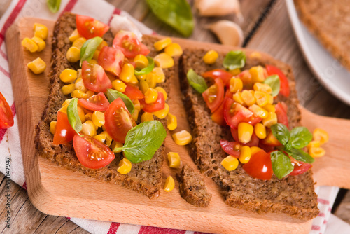 Rye bread withsweet corn, basil and tomato.