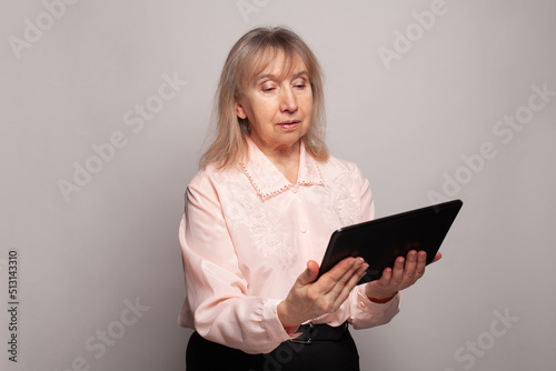 Mature adult woman using computer tablet