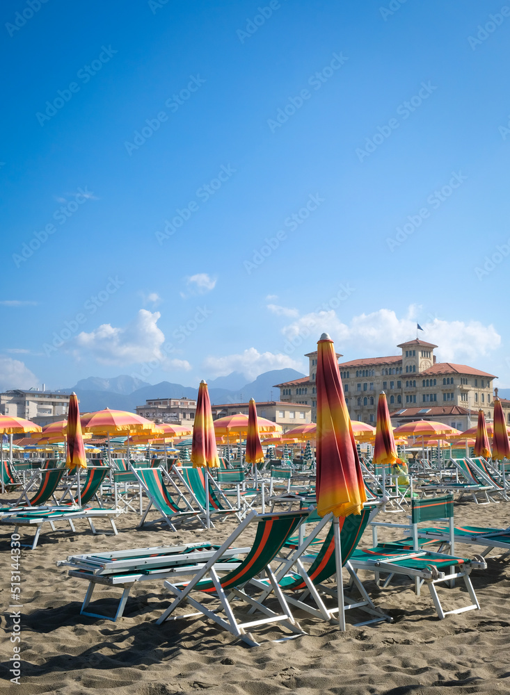 Fototapeta premium Colorful beach umbrellas and classic architecture of Viareggio, Italy with negative space for copy.