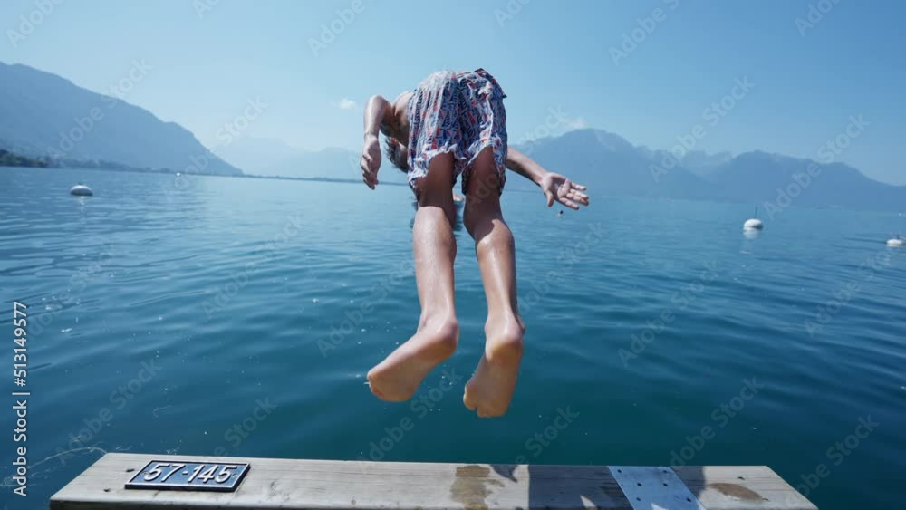 Young boy enjoying summer vacations running on pier and diving into ...