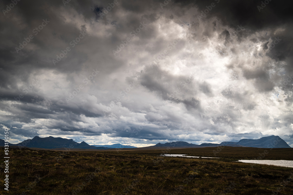 A gloomy, summer, HDR landscape image of Ben Loyal and Ben Hope across a boggy morass with Ben Klibreck in the far distance, Scotland