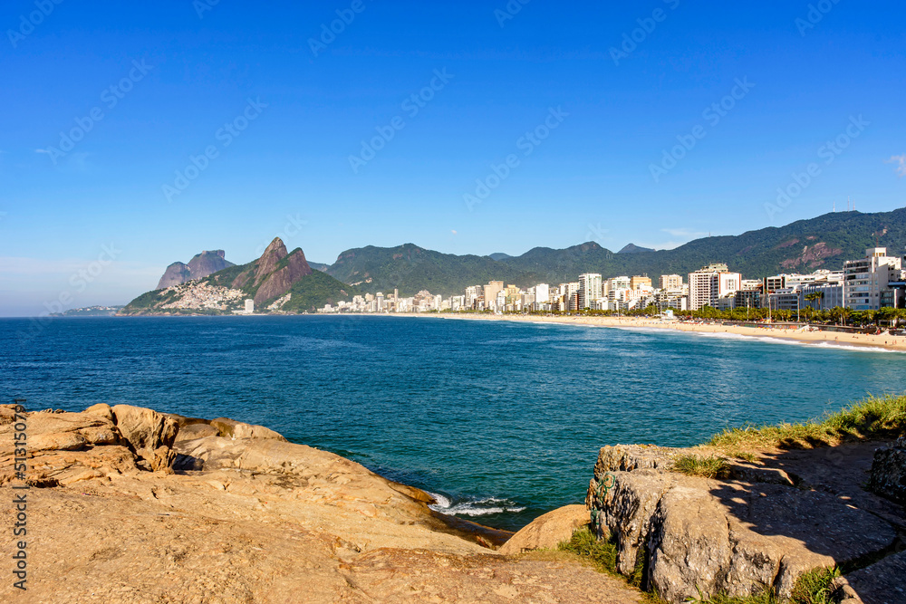 Panorama of Ipanema beach in Rio de Janeiro on a beautiful day with the sea, buildings and hills around in the morning