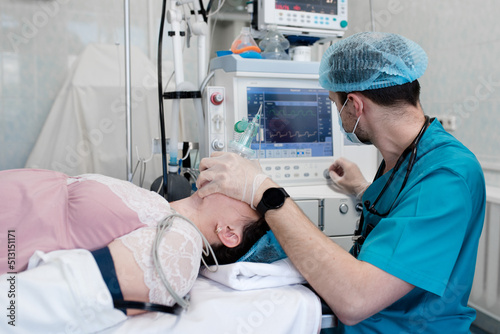 Anesthetist observes the monitor on the ventilator while the patient is being anesthetized.  Anesthetist takes care of anesthesia and ventilation for the patient during the operation photo