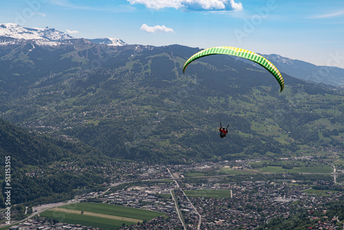 Paragliding over the mountains and a city in the Alps in France