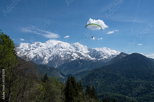 Paragliding over the mountains and a city in the Alps in France