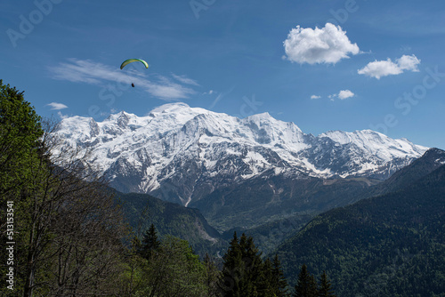 Paragliding over the mountains and a city in the Alps in France