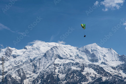 Paragliding over the mountains and a city in the Alps in France