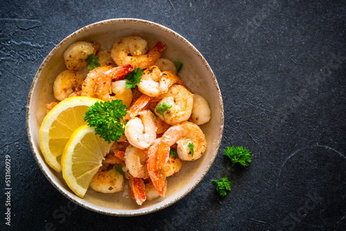 Frying shrimps with lemon in the frying pan.