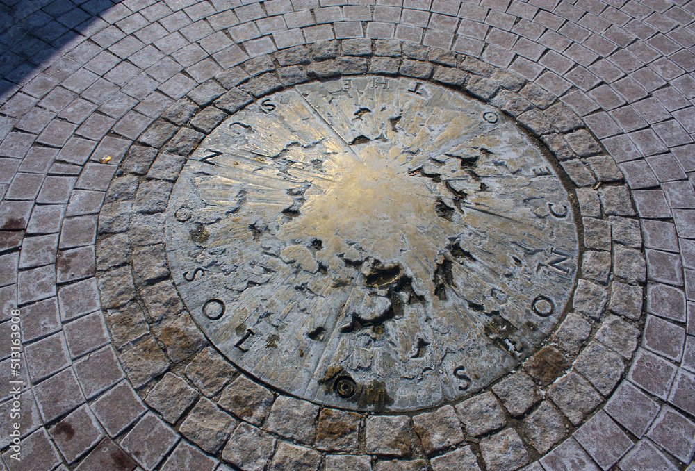 Bronze sun on the ground near the monument to Nicholas Copernicus
