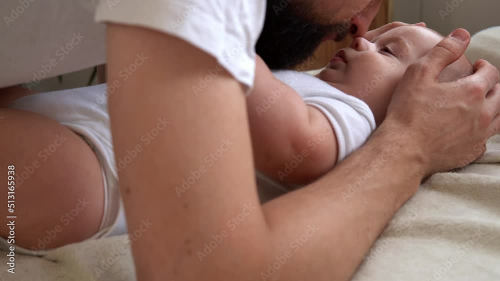 Authentic Bearded Long-haired Young Neo Father And Newborn Baby Looking Each Other Smiling On Bed. Dad Laying With Infant Child. Children, Parenthood, Childhood, Life, Love, Fatherhood, Family Concept Authentic Bearded Long-haired Young Neo Father And Newborn Baby Looking Each Other Smiling On Bed. Dad Laying With Infant Child. Children, Parenthood, Childhood, Life, Love, Fatherhood, Family Concept